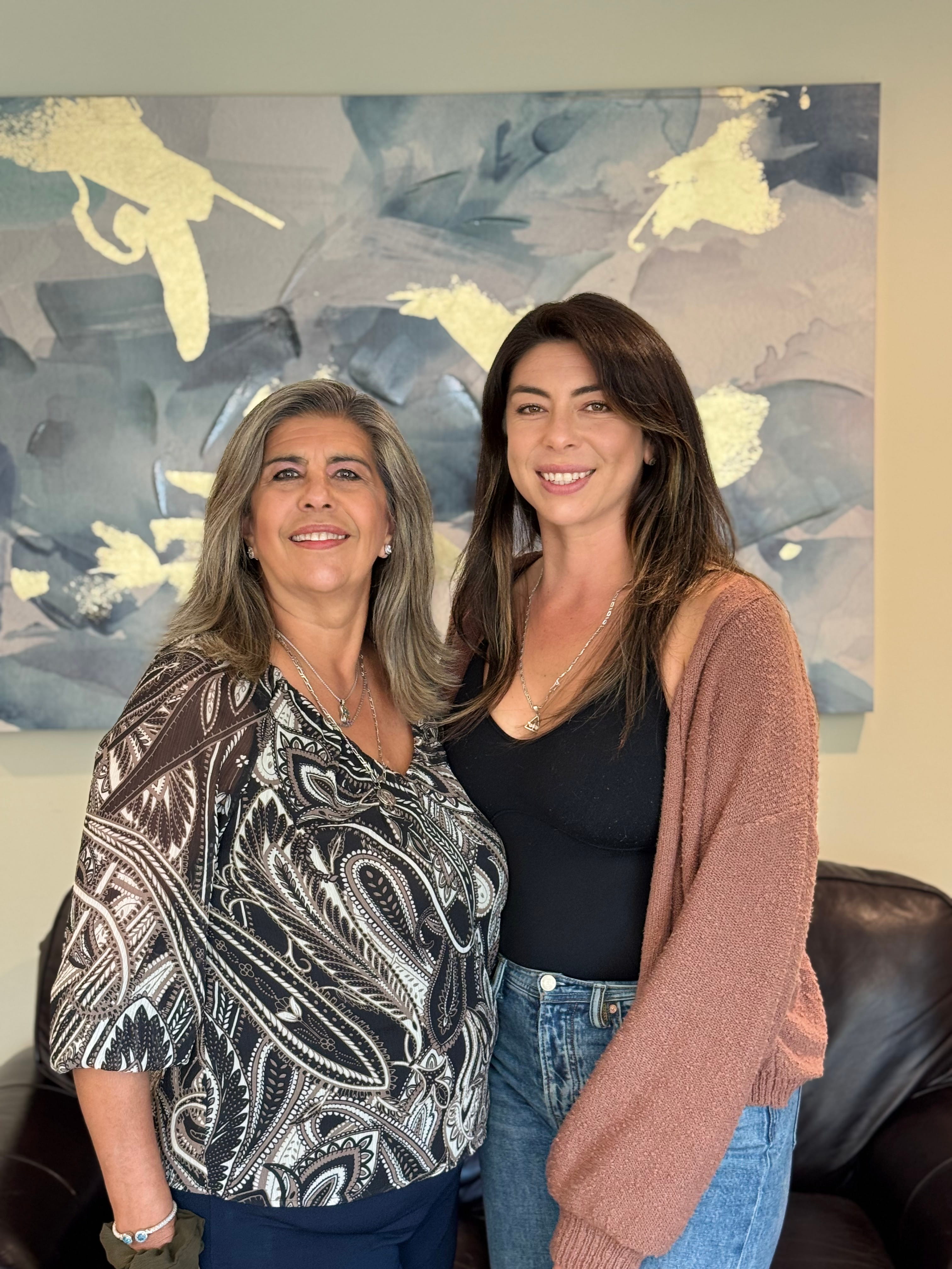 Bessie and Natalie Coello standing next to each other and smiling.