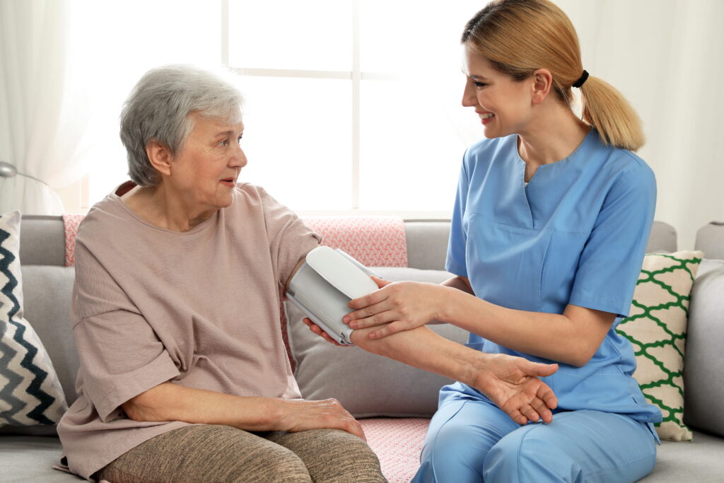 Caregiver taking the blood pressure of a female resident.